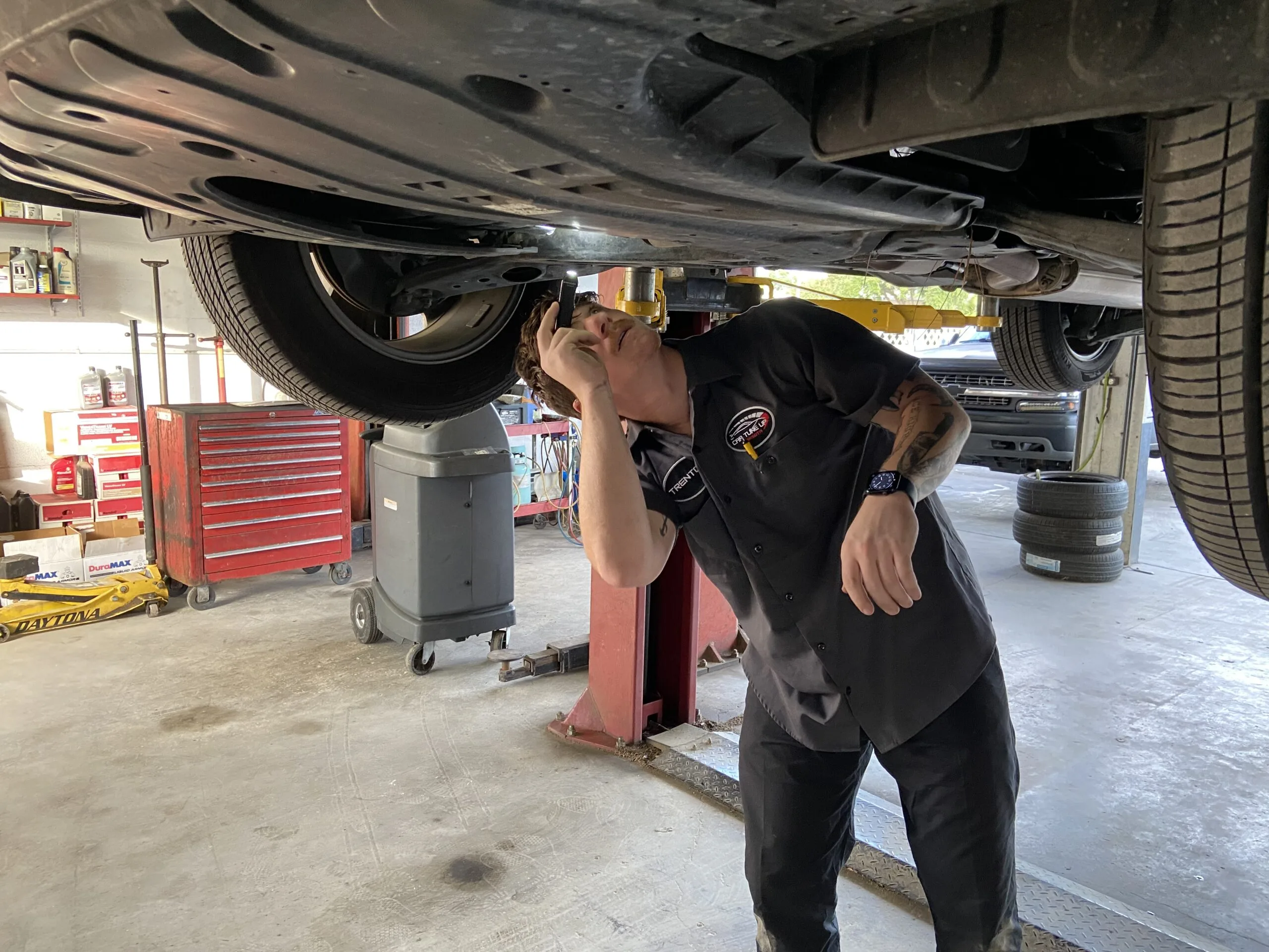 Mechanic performing an oil change on a car engine, demonstrating preventative maintenance services at Car Tune Up – Sarasota.